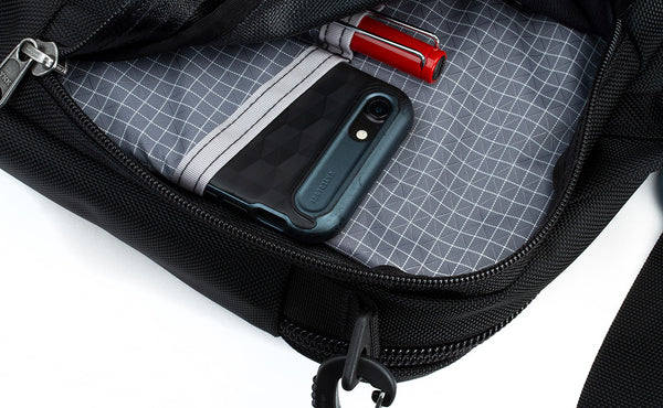 The side compartment of the Pilot with phone and pen inserted into the interior pockets.